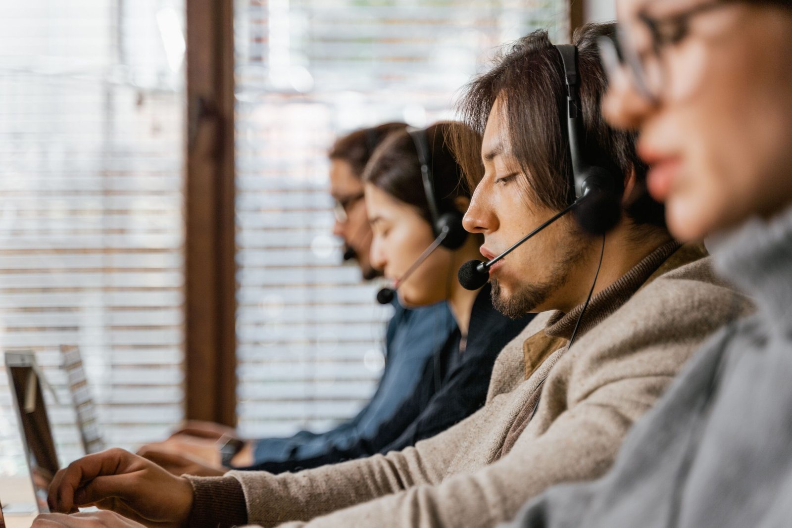 Call center employees working with headsets at their desks in a modern office