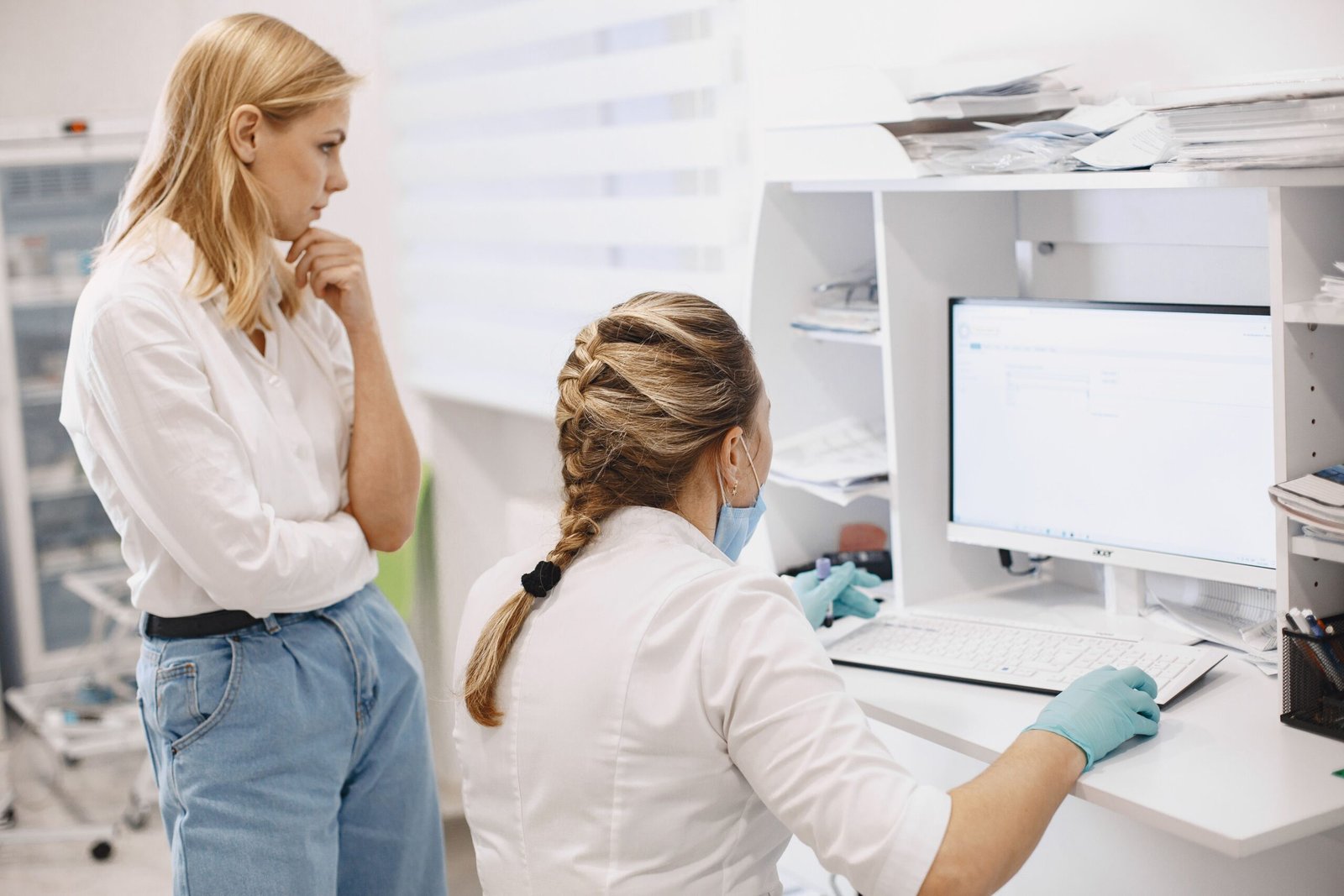 Two healthcare workers reviewing data together on a computer screen in a clinic