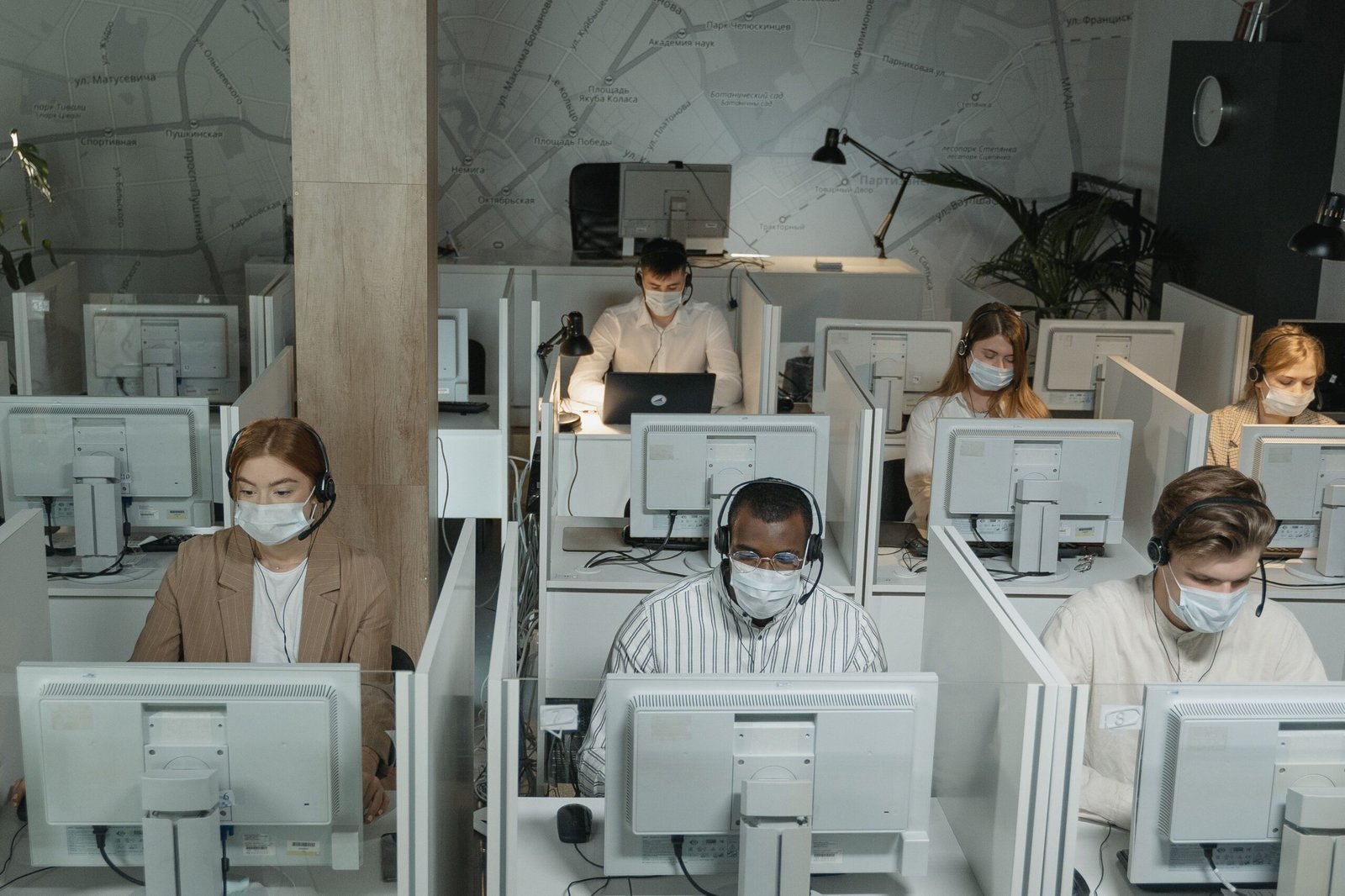 A diverse customer support team collaborating at a bright, modern office workstation