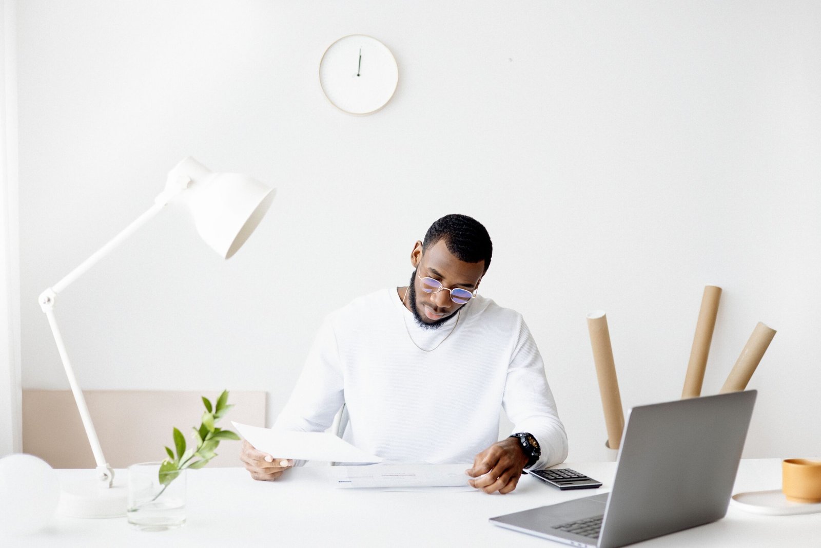A businessperson reviewing information across a laptop and phone at a desk
